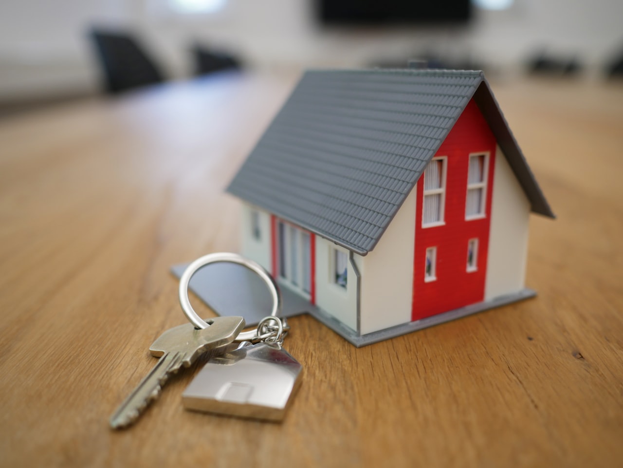 A small model house and keys on a table
