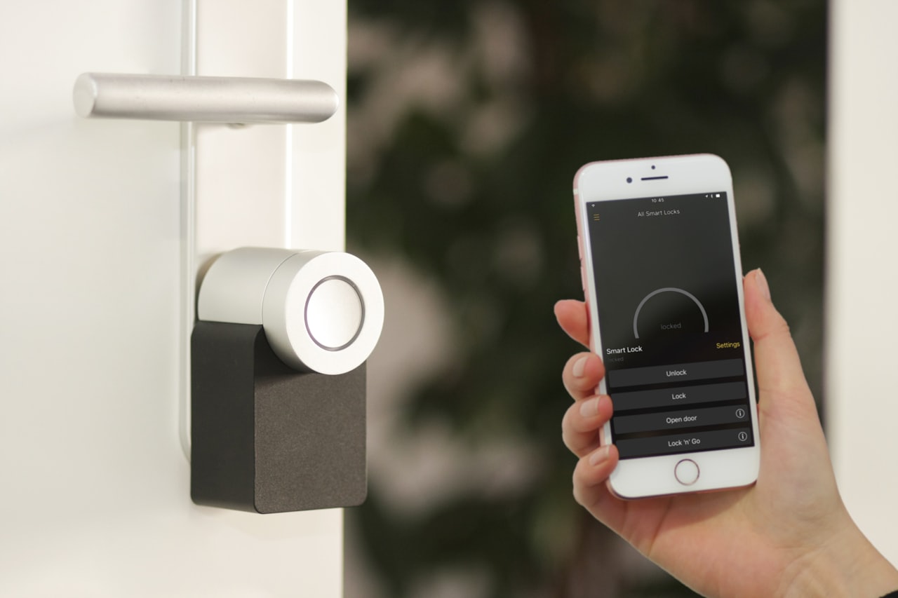 A smartphone held up to a smart lock at a front door